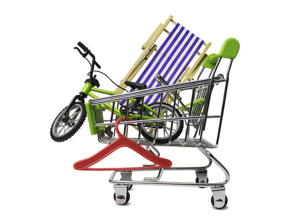 Isolated travel stuff, purchases for journey: bicycle, hanger and chaise-longue in the shopping cart. Tourist concept. - Photo, Image