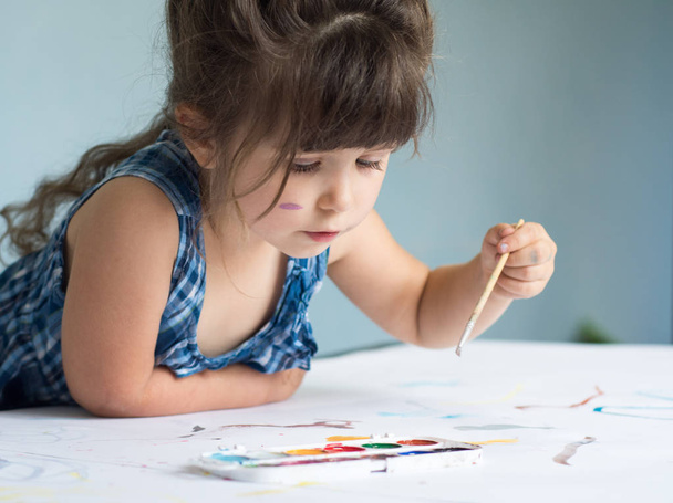 Négy éves gyermek otthon festés. Szép kislány, ecset, akvarell. - Fotó, kép