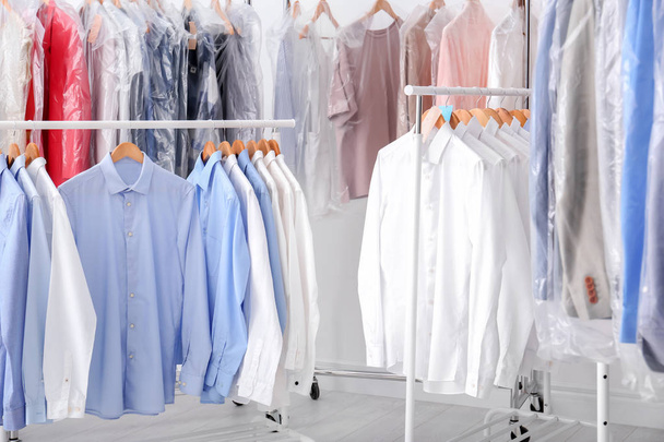 Racks with clean clothes on hangers after dry-cleaning indoors - Фото, изображение