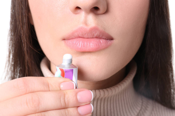 Young woman applying cold sore cream on lips, closeup - Фото, изображение