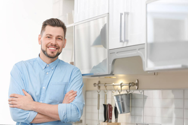 Portrait of handsome young man in kitchen - Φωτογραφία, εικόνα