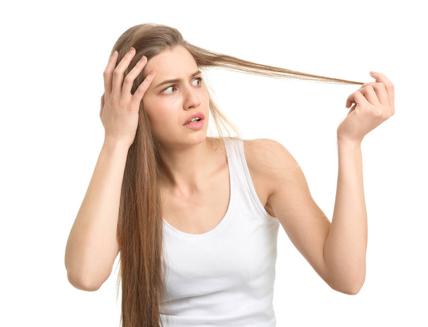 Nuori nainen, jolla on hiustenlähtö ongelma valkoisella taustalla
 - Valokuva, kuva