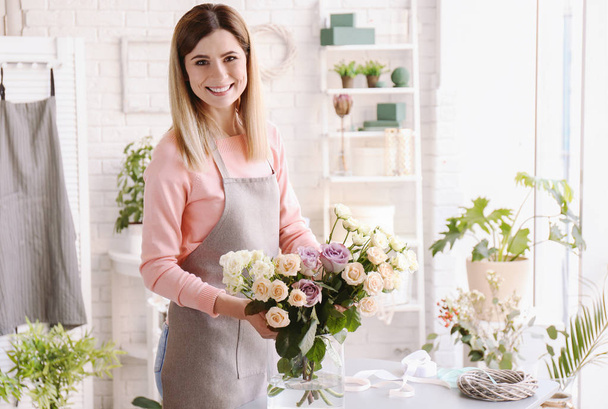 Female florist with roses at workplace - Φωτογραφία, εικόνα