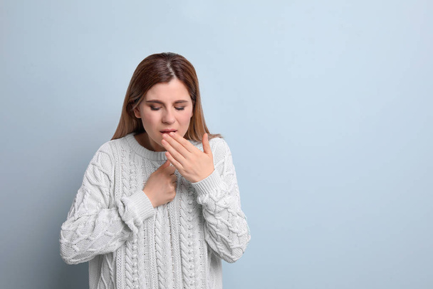 Woman coughing on color background - Fotó, kép