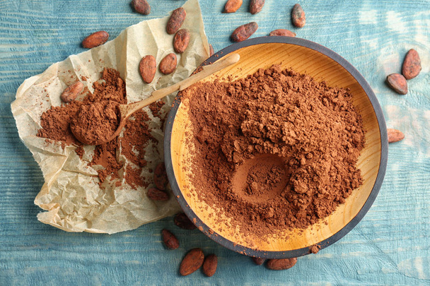 Flat lay composition with cocoa powder and beans on wooden background - Zdjęcie, obraz