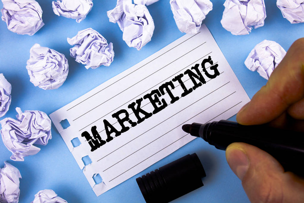 Textmarketing. Geschäftsidee für Werbung für den Verkauf von Produkten eines Unternehmens, um etwas zu fördern, das von Menschen auf Notizblock-Papier auf einfachem blauem Hintergrund geschrieben wurde.. - Foto, Bild