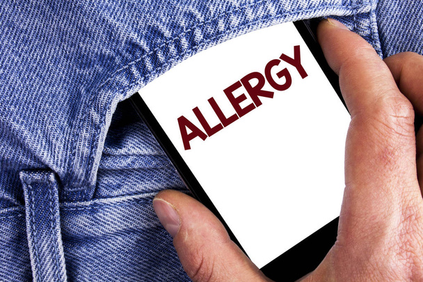 Writing note showing  Allergy. Business photo showcasing damages in immunity due to hypersensitivity get it diagnised written on Mobile phone screen holding by man on the Jeans background. - Photo, Image