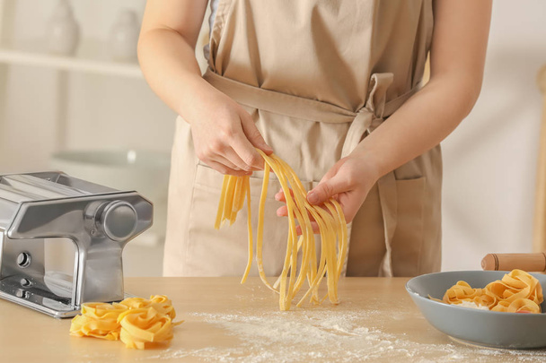 Woman preparing pasta at table - 写真・画像