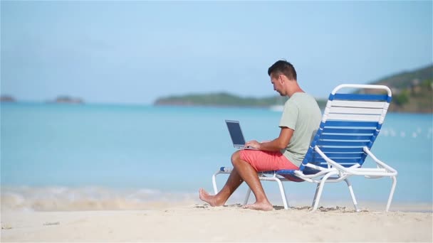 熱帯のビーチの休暇中にタブレットコンピュータを持つ若い男 - 映像、動画