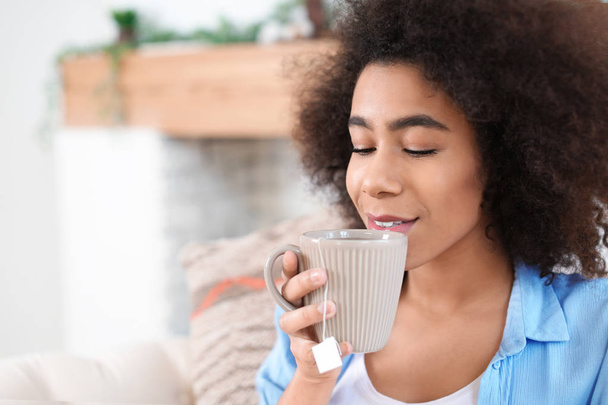 Mulher afro-americana bonita bebendo chá em casa
 - Foto, Imagem