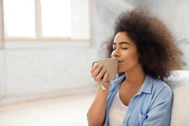 Όμορφη Αφρικανικός-αμερικανική γυναίκα πίνοντας τσάι στο σπίτι - Φωτογραφία, εικόνα