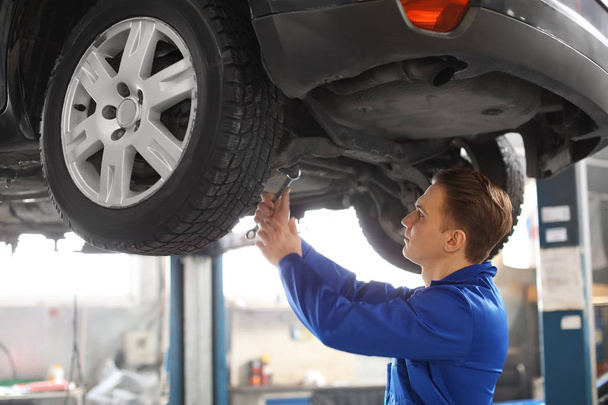 Male mechanic fixing car in service center - Zdjęcie, obraz