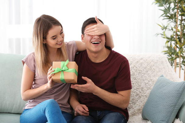 若い女性の自宅に彼女の最愛の彼氏にプレゼントを与える - 写真・画像