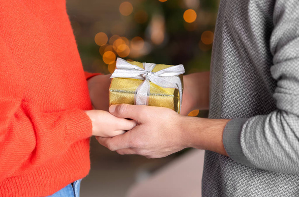 Young loving couple with gift box at home, closeup - Photo, Image