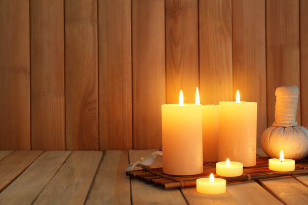 Красивий спа-набір з палаючими свічками на дерев'яному фоні
 - Фото, зображення