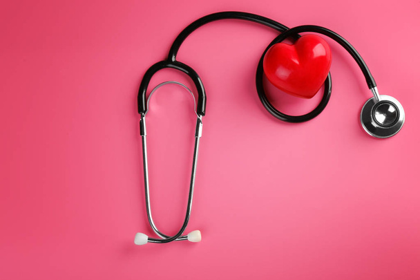 Stethoskop mit kleinem Herzen auf farbigem Hintergrund - Foto, Bild
