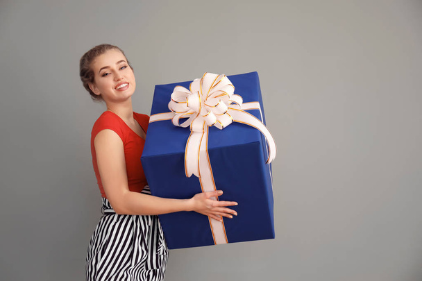 Bella giovane donna con grande scatola regalo su sfondo di colore
 - Foto, immagini
