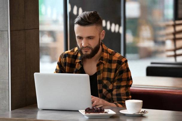 Giovane freelance con computer portatile che lavora in caffè
 - Foto, immagini