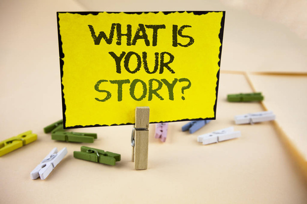 Schreiben Notiz zeigt, was Ihre Geschichte Frage ist. Geschäftsfotos, die persönliche Erfahrungen aus der Vergangenheit erzählen, auf gelbem Klebepapier auf schlichtem Hintergrund mit Holzklammern geschrieben. - Foto, Bild