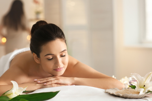 junge Frau entspannt auf Massagetisch im Wellness-Salon - Foto, Bild