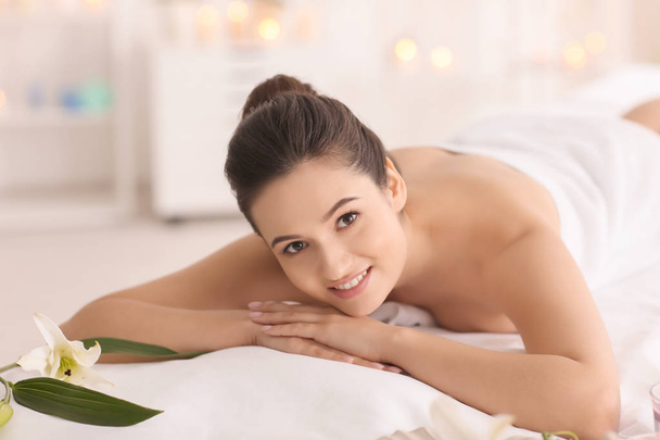 mujer joven relajándose en la mesa de masaje en el salón de spa
 - Foto, imagen