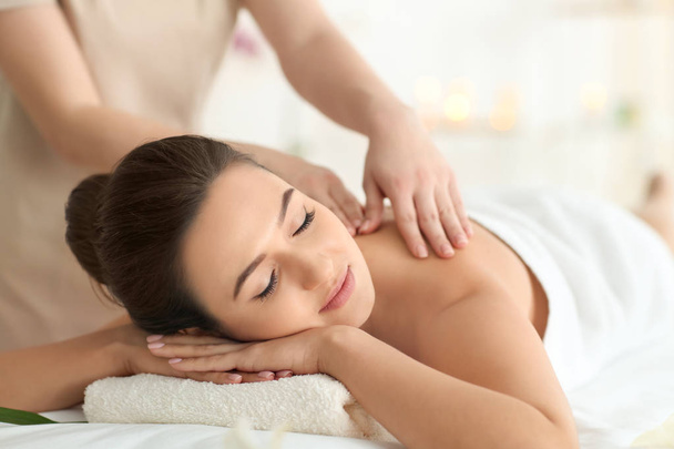 Jovem mulher recebendo massagem no salão de spa
 - Foto, Imagem