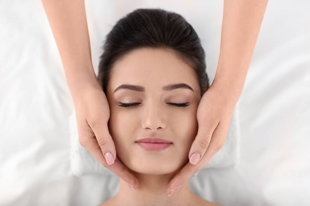 Young woman receiving face massage in spa salon, top view - Fotografie, Obrázek