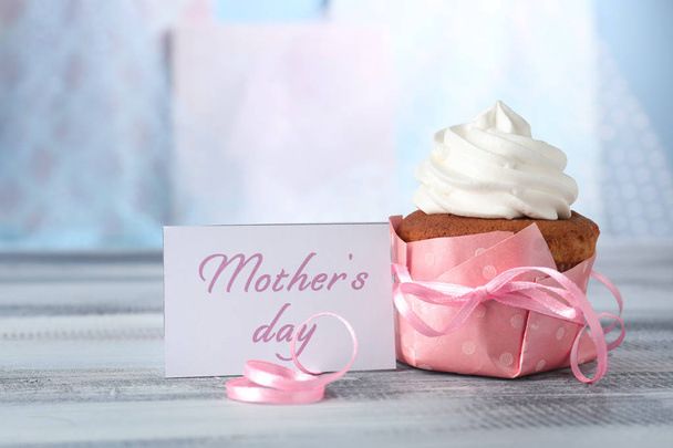 Νόστιμο cupcake του και κάρτα με την ημέρα της μητέρας λέξεις στον πίνακα θολή φόντο - Φωτογραφία, εικόνα