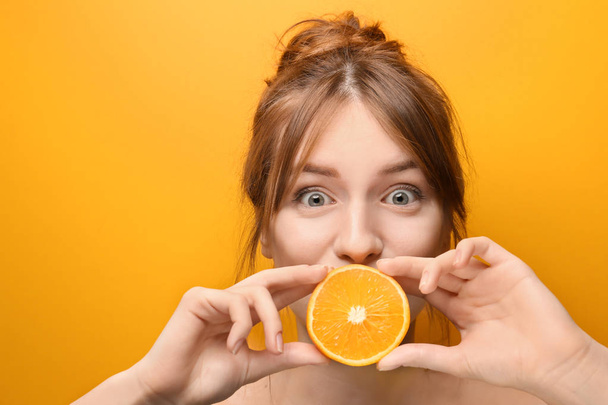 Beautiful funny young woman with citrus fruit on color background - Fotoğraf, Görsel
