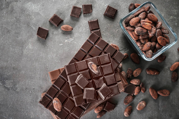 Вкусный шоколад и бобы какао на столе, вид сверху
 - Фото, изображение