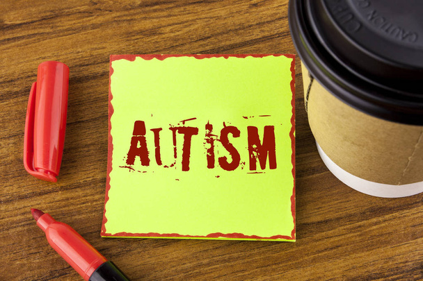 Uwaga: pisanie Wyświetlono Autyzm. Biznesowe zdjęcie prezentujący autyzmu, prowadzone przez społeczny Komitet na świecie napisane na Przyklejony papier firmowy na tle drewniany puchar znacznik obok niego - Zdjęcie, obraz