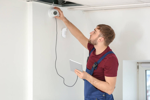 Electrician installing security camera indoors - Fotografie, Obrázek