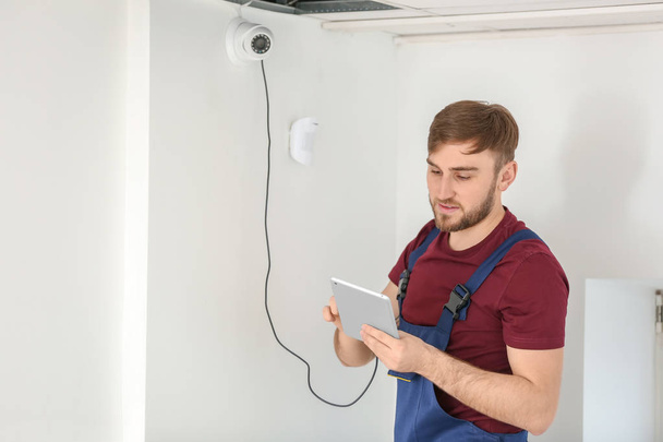 Electrician installing security camera indoors - Photo, Image