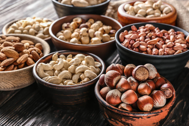 Bowls with different nuts on wooden table - Photo, Image