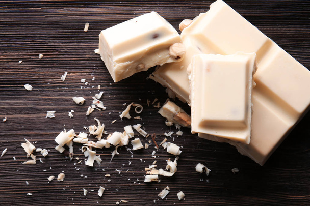 Pieces of white chocolate on wooden table - Photo, image