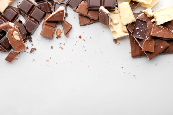 Diferentes piezas de chocolate sobre fondo blanco
 - Foto, imagen