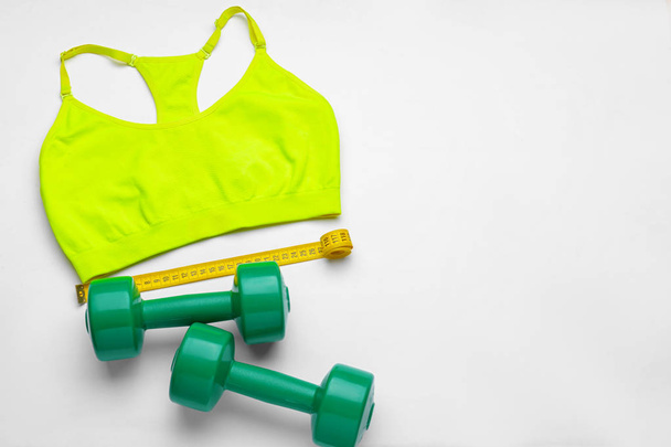 Composition with sportswear, dumbbells and measuring tape on white background - Photo, Image