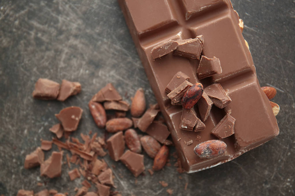 Вкусный шоколад, какао-бобы и стружки на столе
 - Фото, изображение
