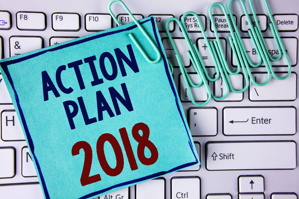 Λέξη σύνταξη κειμένου 2018 σχέδιο δράσης. Επιχειρηματική ιδέα για να κάνουμε λίστα στη το ψήφισμα του νέου έτους το νέο έτος τους στόχους στόχων γραμμένο σε κολλώδη σημείωση χαρτί τοποθετείται σε πληκτρολόγιο λευκό χαρτί καρφίτσες δίπλα. - Φωτογραφία, εικόνα