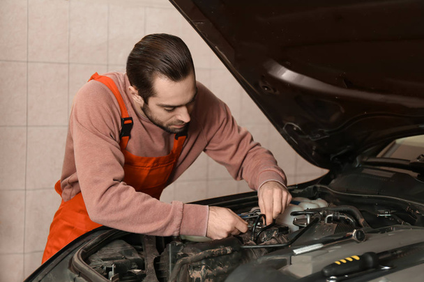 Jeune mécanicien automobile réparation de voiture dans le centre de service
 - Photo, image