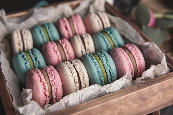 Crate with tasty macarons on table - Photo, Image
