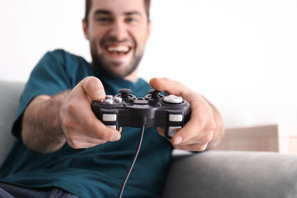 Młody człowiek gra w gry wideo w domu - Zdjęcie, obraz