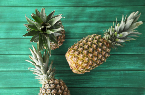 Tasty pineapples on wooden table - Фото, изображение