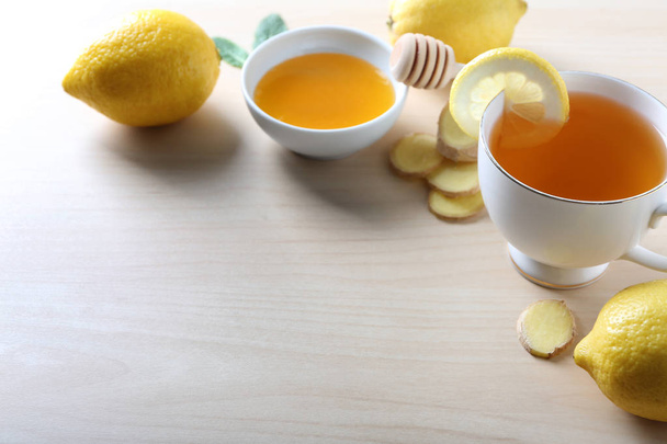 Šálek lahodného čaje se zázvorem, citronem a medem na stole - Fotografie, Obrázek
