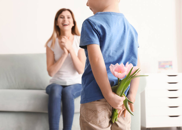 Cute little boy hiding flowers for mother behind his back - Foto, immagini