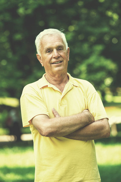 Portrait of smiling elderly man outdoor in park - Foto, Imagem