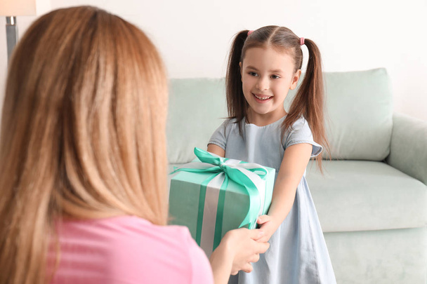 Mother receiving gift from her cute little daughter at home - Foto, imagen