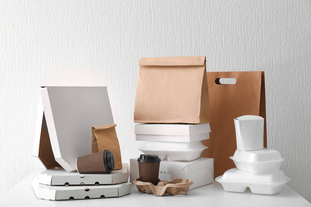 Sortimento de recipientes de entrega de alimentos em mesa branca
 - Foto, Imagem