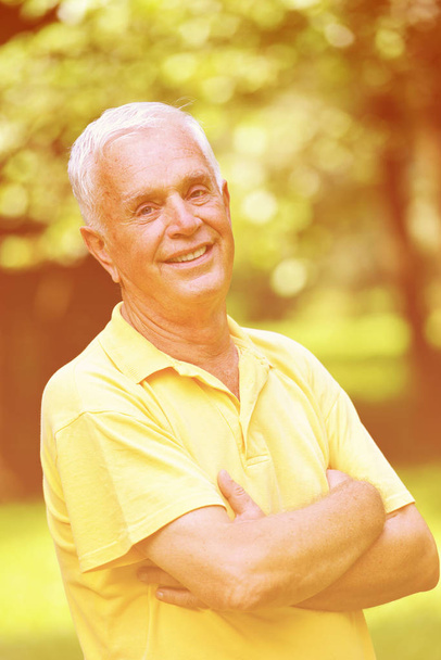 glücklicher gesunder und fitter älterer Mann Porträt in grünem Hintergrund Park - Foto, Bild