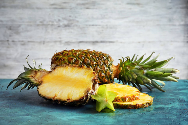 Ripe fresh pineapples and starfruit on table - Foto, Imagem